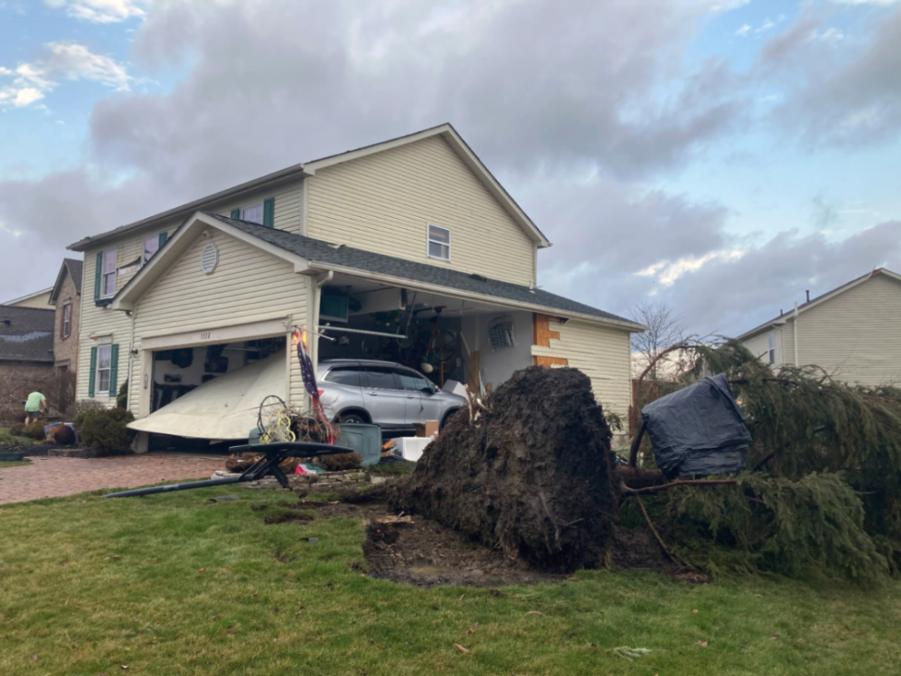 Storm damage to Minnesota home with uprooted tree and structural damage